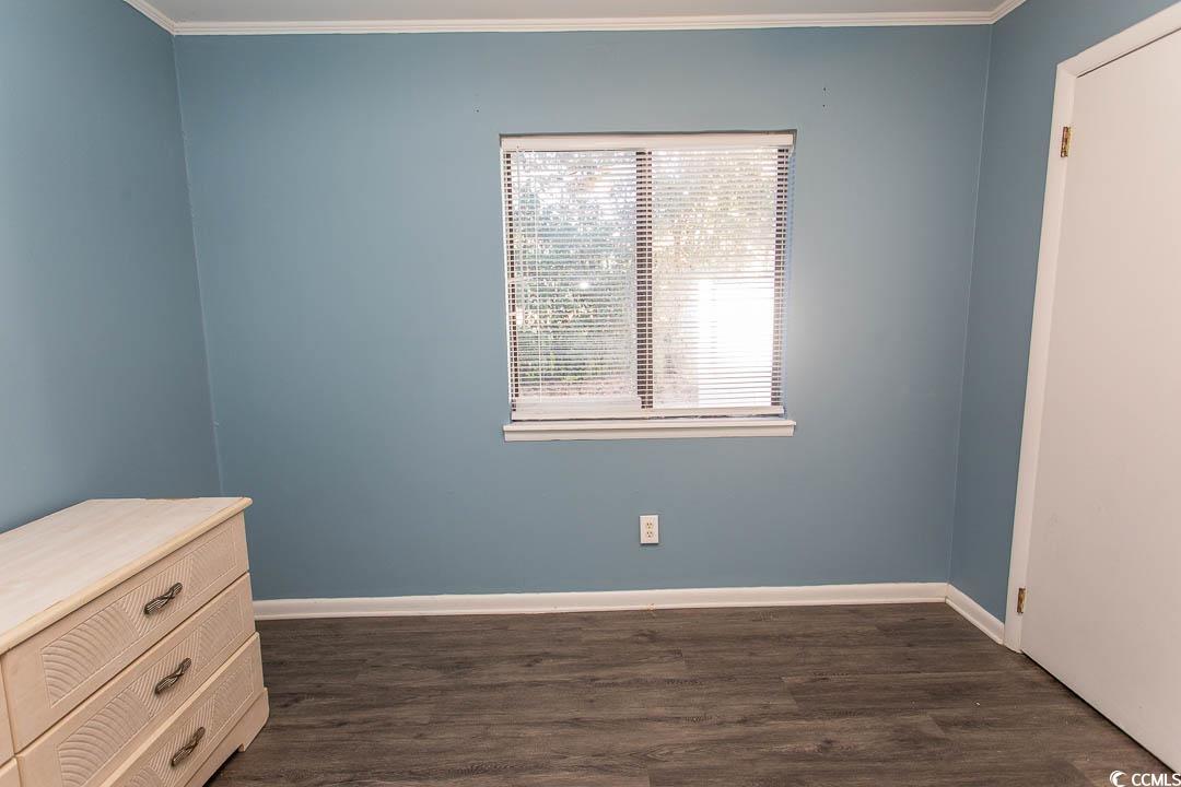950 Forestbrook Road, Unit C3 Myrtle Beach, SC 29579 - Photo 7 of 19 Empty room with dark wood-type flooring and crown molding