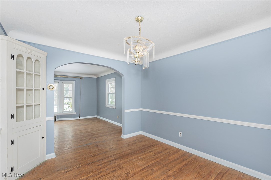 3719 Berkeley Road Cleveland Heights, OH 44118 - Photo 19 of 44 Unfurnished room with arched walkways, wood finished floors, and a chandelier