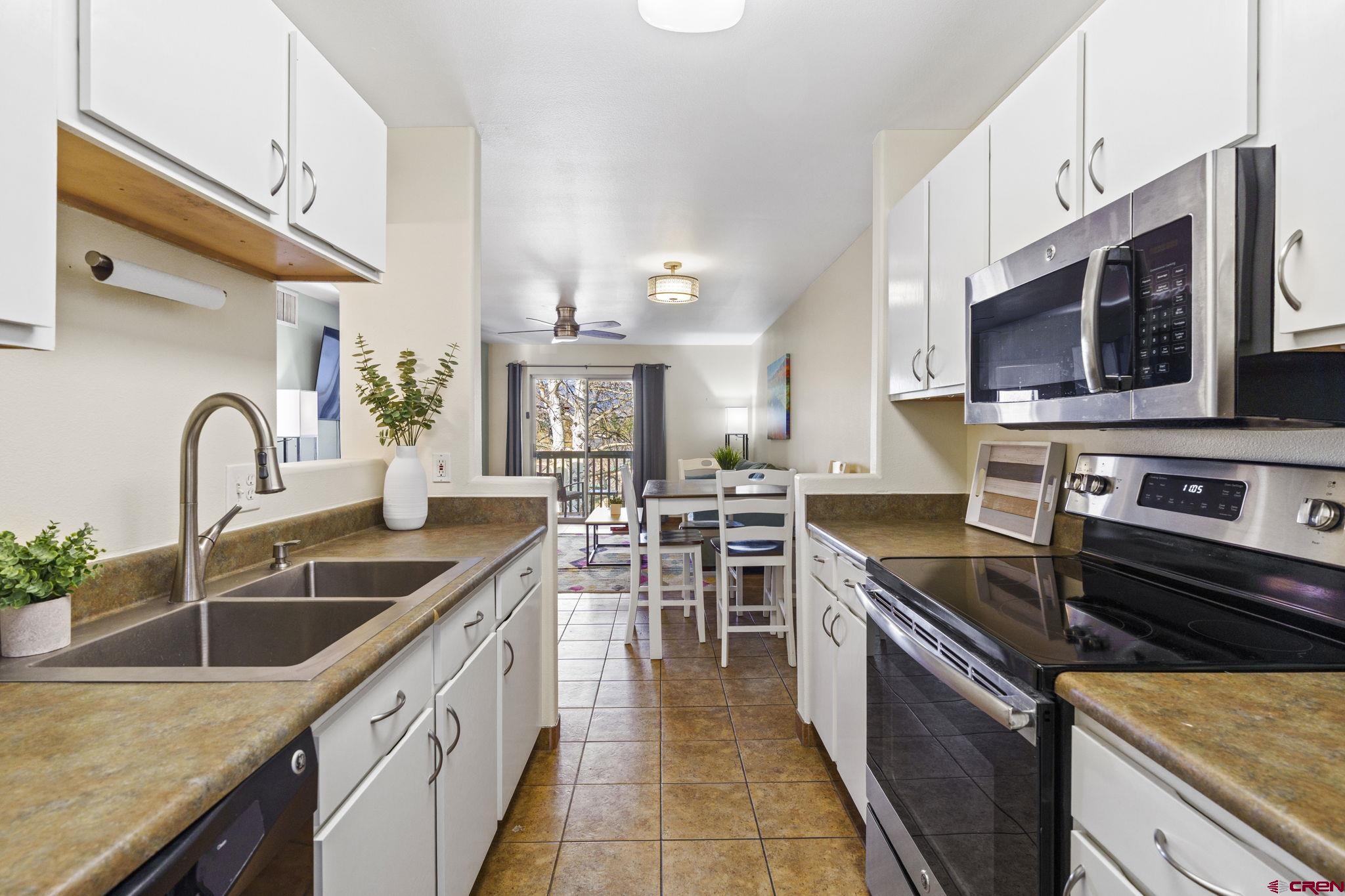 1100 Goeglein Gulch Road, Unit 233 Durango, CO 81301 - Photo 11 of 37 a kitchen with stainless steel appliances granite countertop a sink stove and microwave