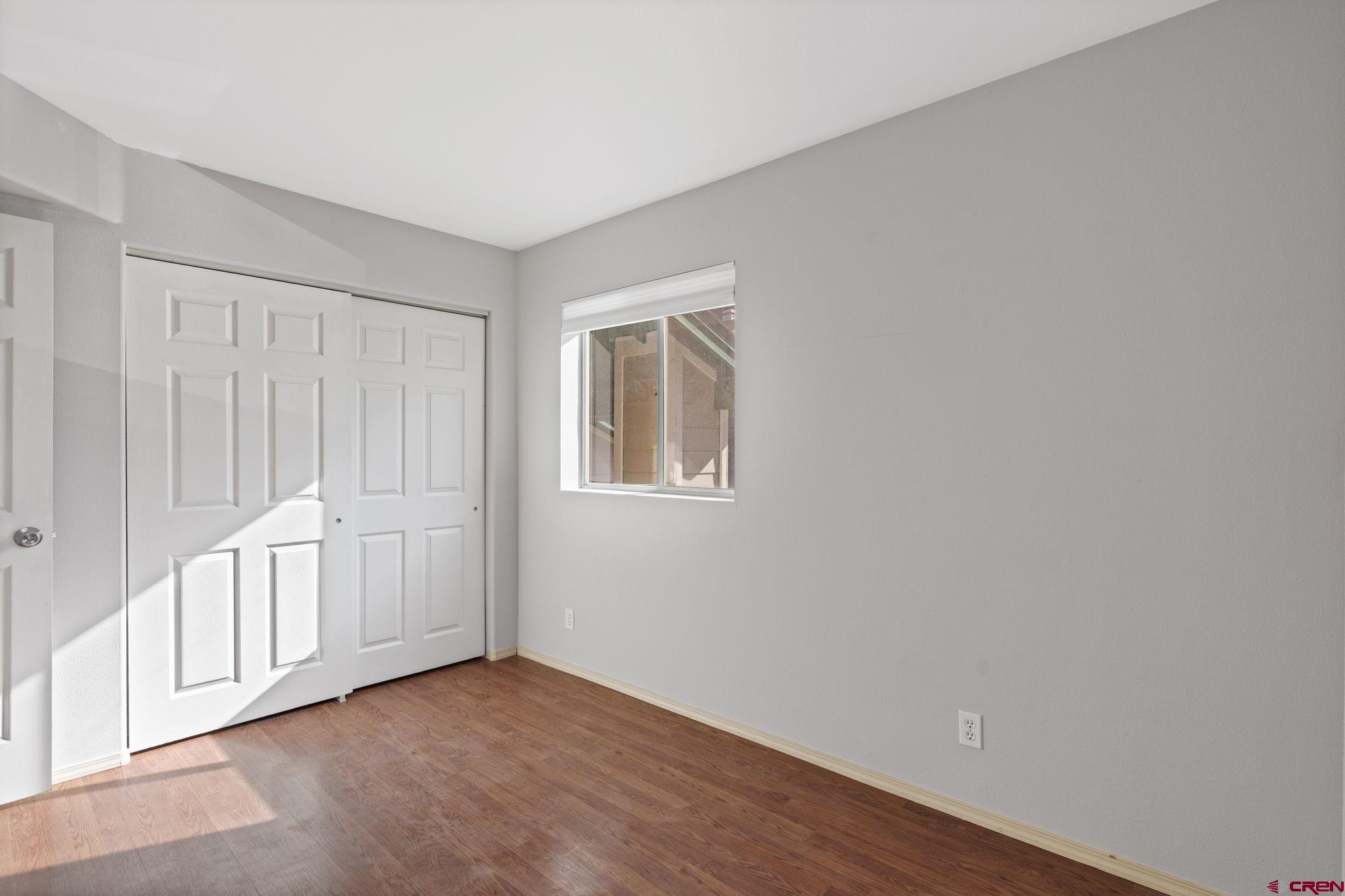 1100 Goeglein Gulch Road, Unit 233 Durango, CO 81301 - Photo 19 of 37 an empty room with wooden floor and windows