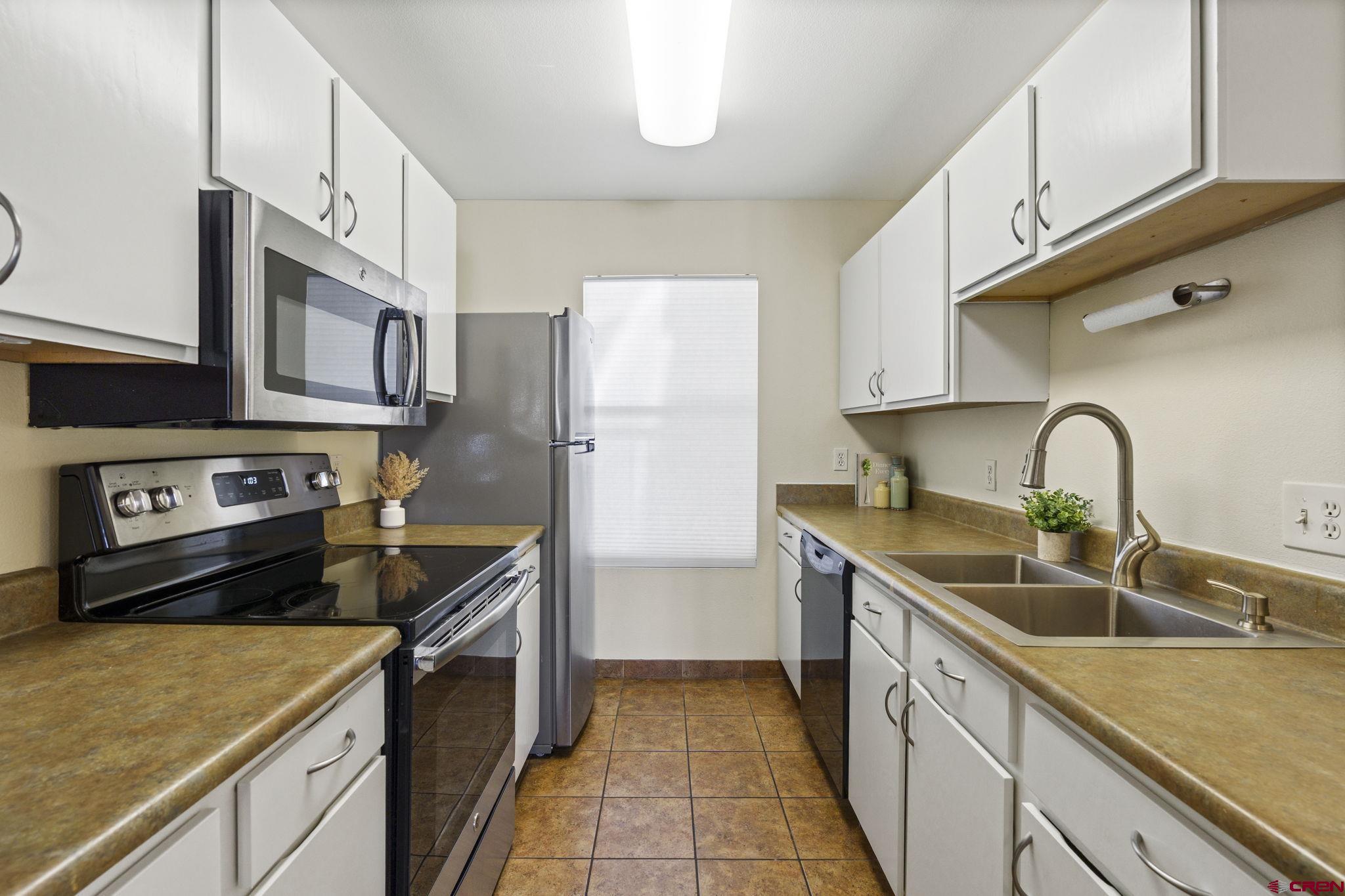 1100 Goeglein Gulch Road, Unit 233 Durango, CO 81301 - Photo 8 of 37 a kitchen with stainless steel appliances granite countertop a sink stove and refrigerator