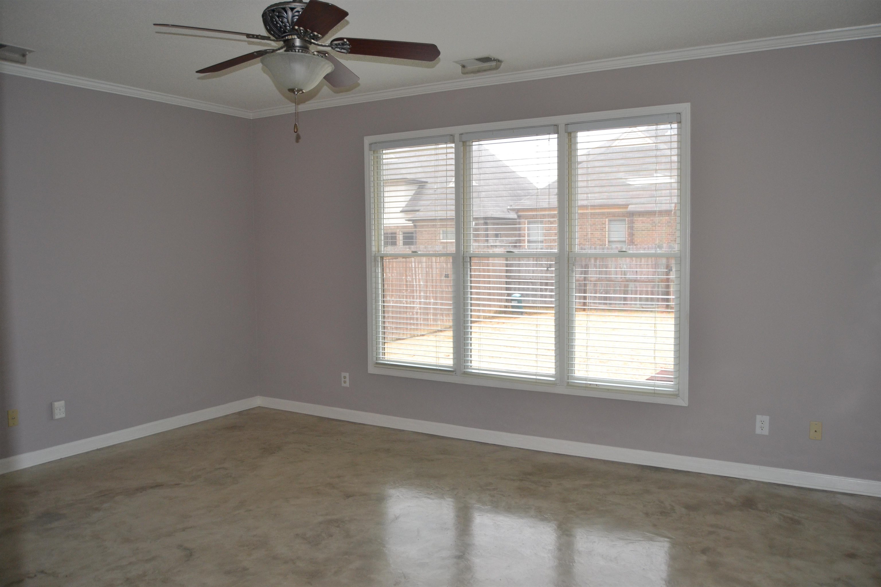 10486 Juneau Way Collierville, TN 38017 - Photo 10 of 33 Empty room with ceiling fan, plenty of natural light, concrete flooring, and ornamental molding