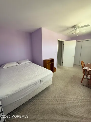 a spacious bedroom with a bed and chair