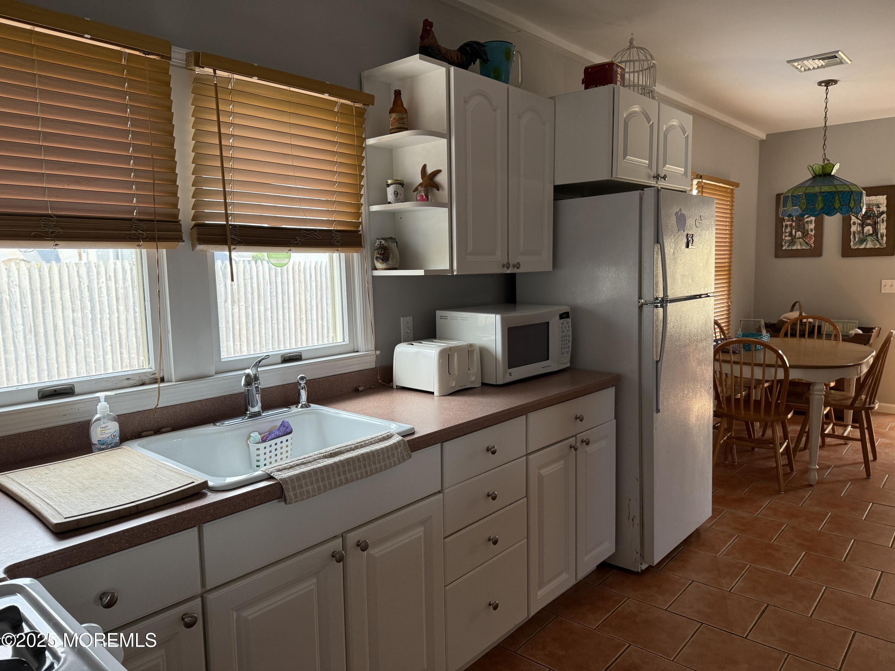 62 A Inlet Drive Point Pleasant Beach, NJ 08742 - Photo 21 of 24 a kitchen with stainless steel appliances sink refrigerator and cabinets