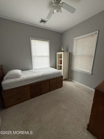 a bedroom with a bed dresser and a window