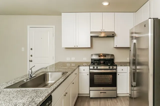 a kitchen with granite countertop a sink stainless steel appliances and cabinets