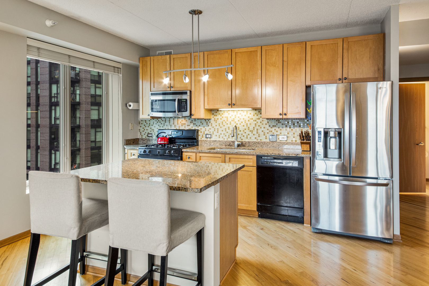 515 Main Street, Unit 505 Evanston, IL 60202 - Photo 4 of 15 a kitchen with kitchen island a large window appliances and cabinets