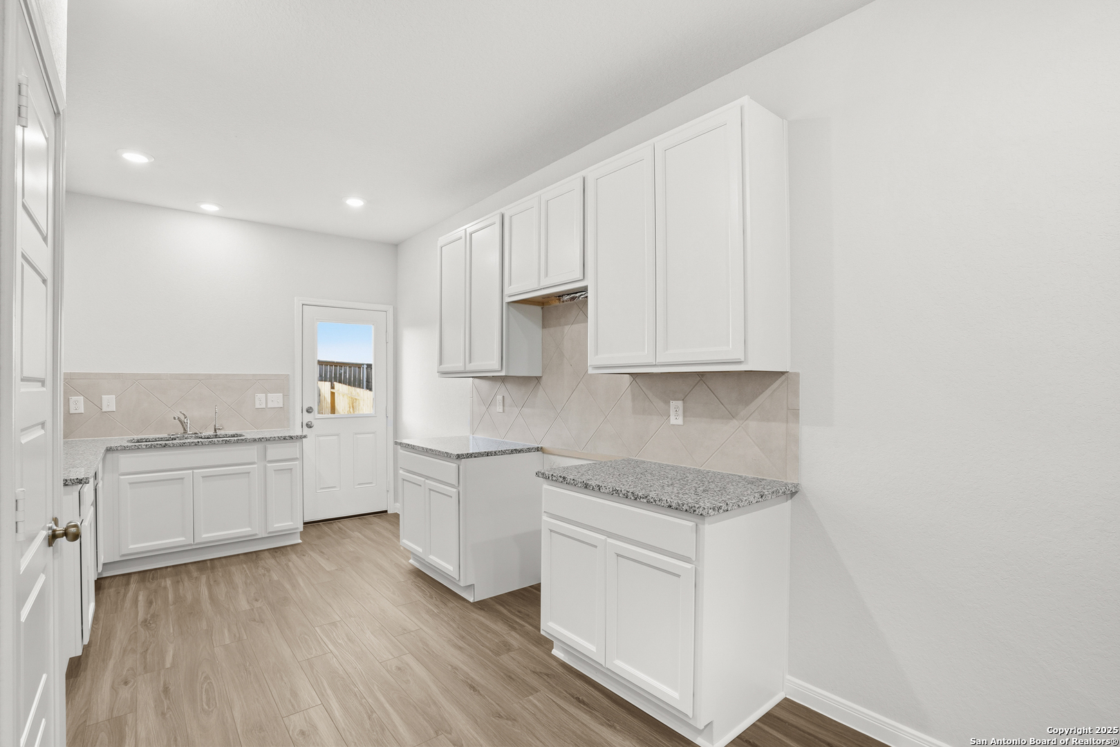 3211 Katzer Lane Converse, TX 78109 - Photo 9 of 28 a kitchen with white cabinets and appliances