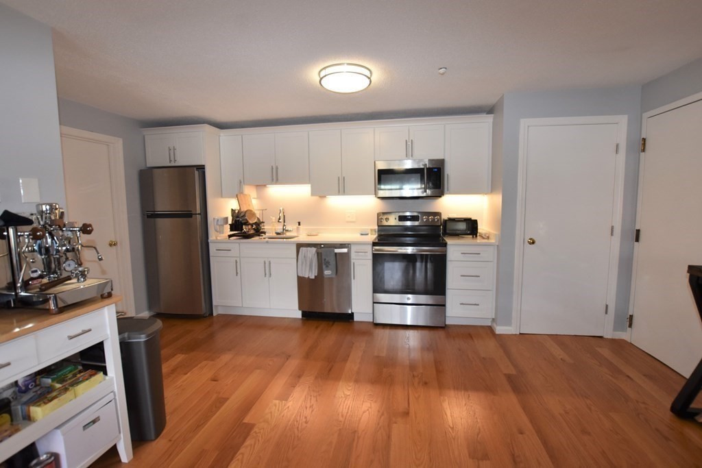 88 Charles Street, Unit 1 Waltham, MA 02453 - Photo 3 of 14 a kitchen with a refrigerator and a stove top oven