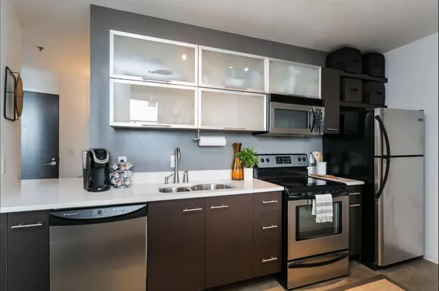 a kitchen with stainless steel appliances a sink dishwasher stove refrigerator and microwave