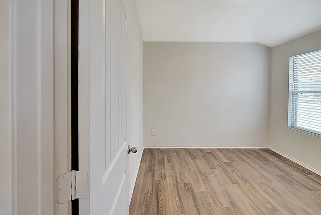 a view of a room with wooden floor and a window