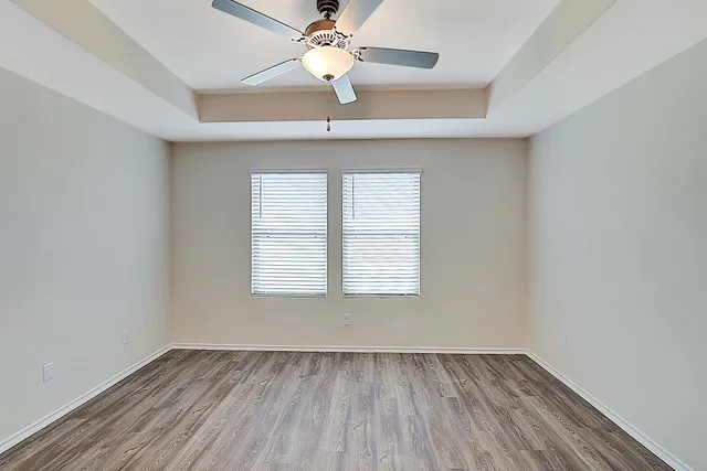 an empty room with a window and wooden floor