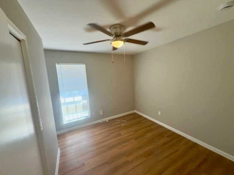 2012 Margalene Way, Unit B Austin, TX 78728 - Photo 8 of 14 an empty room with wooden floor fan and windows