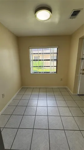 a view of a refrigerator in kitchen and an empty room