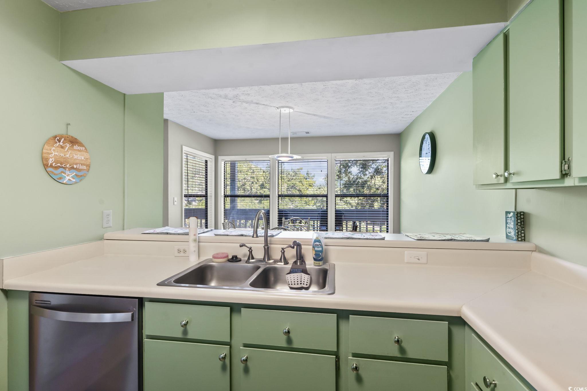 310 5th Avenue North, Unit 206 Surfside Beach, SC 29575 - Photo 11 of 40 Kitchen with green cabinets, stainless steel dishwasher, light countertops, a textured ceiling, and a peninsula
