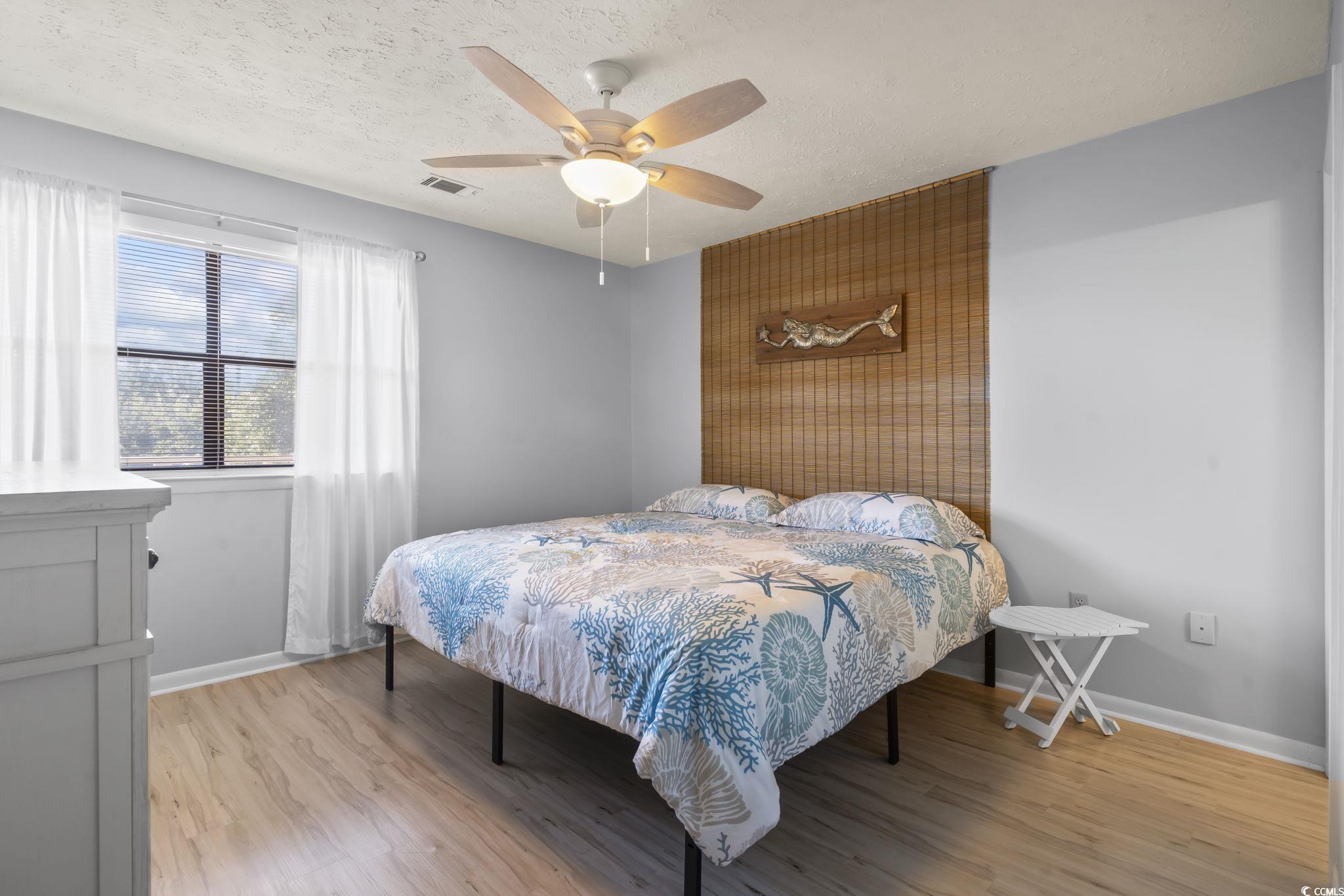 310 5th Avenue North, Unit 206 Surfside Beach, SC 29575 - Photo 14 of 40 Bedroom featuring a textured ceiling, light wood finished floors, and ceiling fan