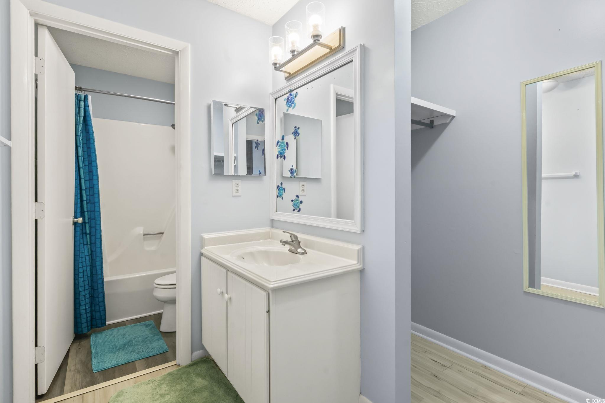 310 5th Avenue North, Unit 206 Surfside Beach, SC 29575 - Photo 17 of 40 Full bath featuring light wood-style flooring, vanity, and shower / bath combination with curtain