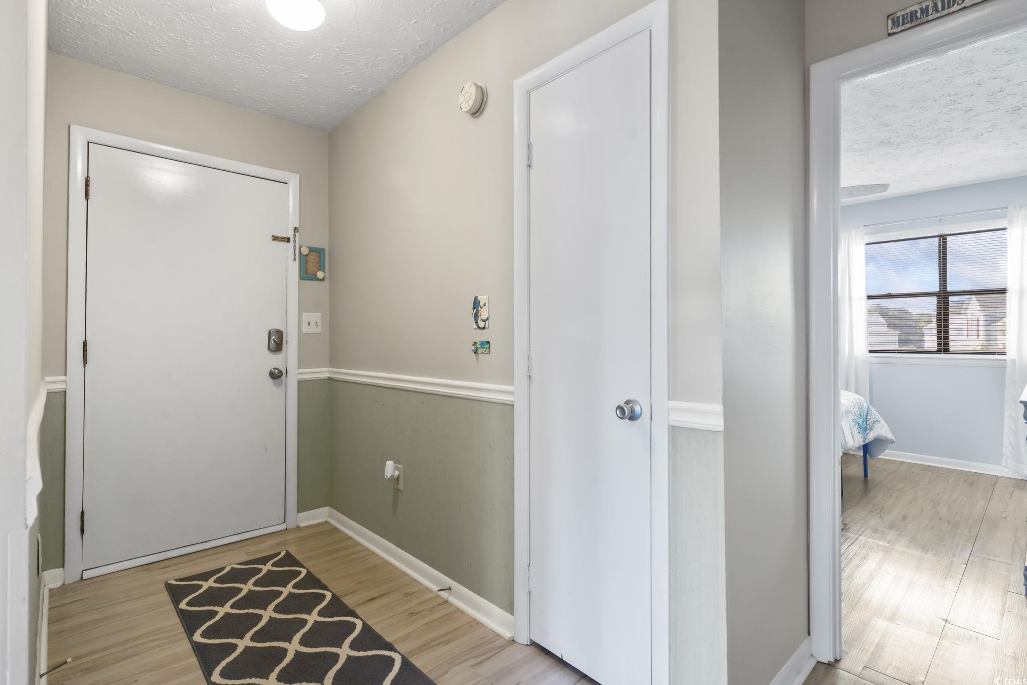 310 5th Avenue North, Unit 206 Surfside Beach, SC 29575 - Photo 22 of 40 Foyer entrance with a textured ceiling and light wood-type flooring
