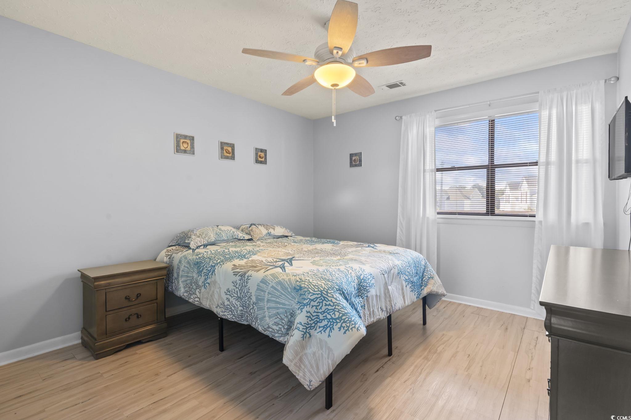 310 5th Avenue North, Unit 206 Surfside Beach, SC 29575 - Photo 26 of 40 Bedroom with light wood-type flooring, a textured ceiling, and ceiling fan