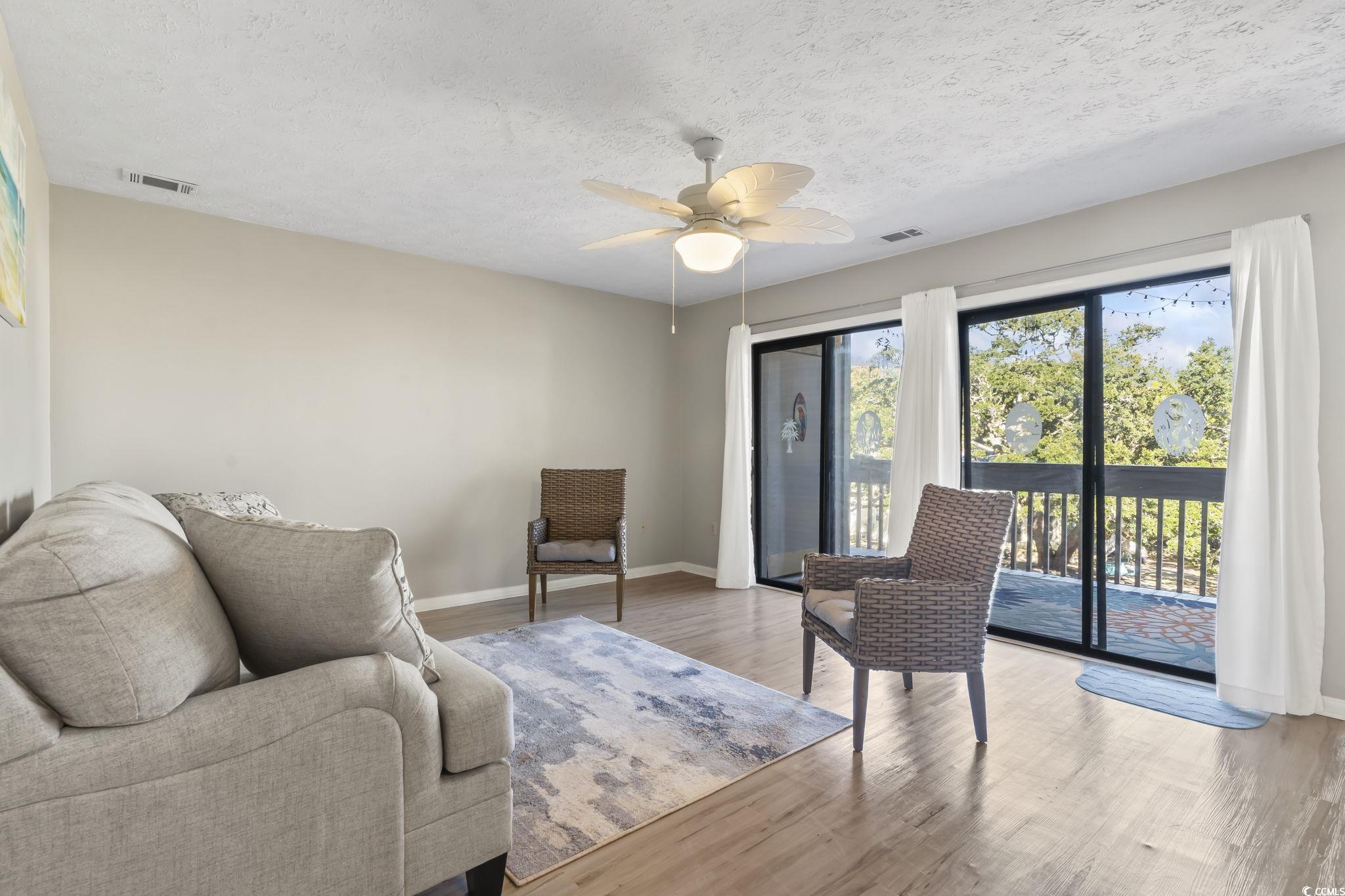 310 5th Avenue North, Unit 206 Surfside Beach, SC 29575 - Photo 3 of 40 Living area with a textured ceiling, wood finished floors, and ceiling fan