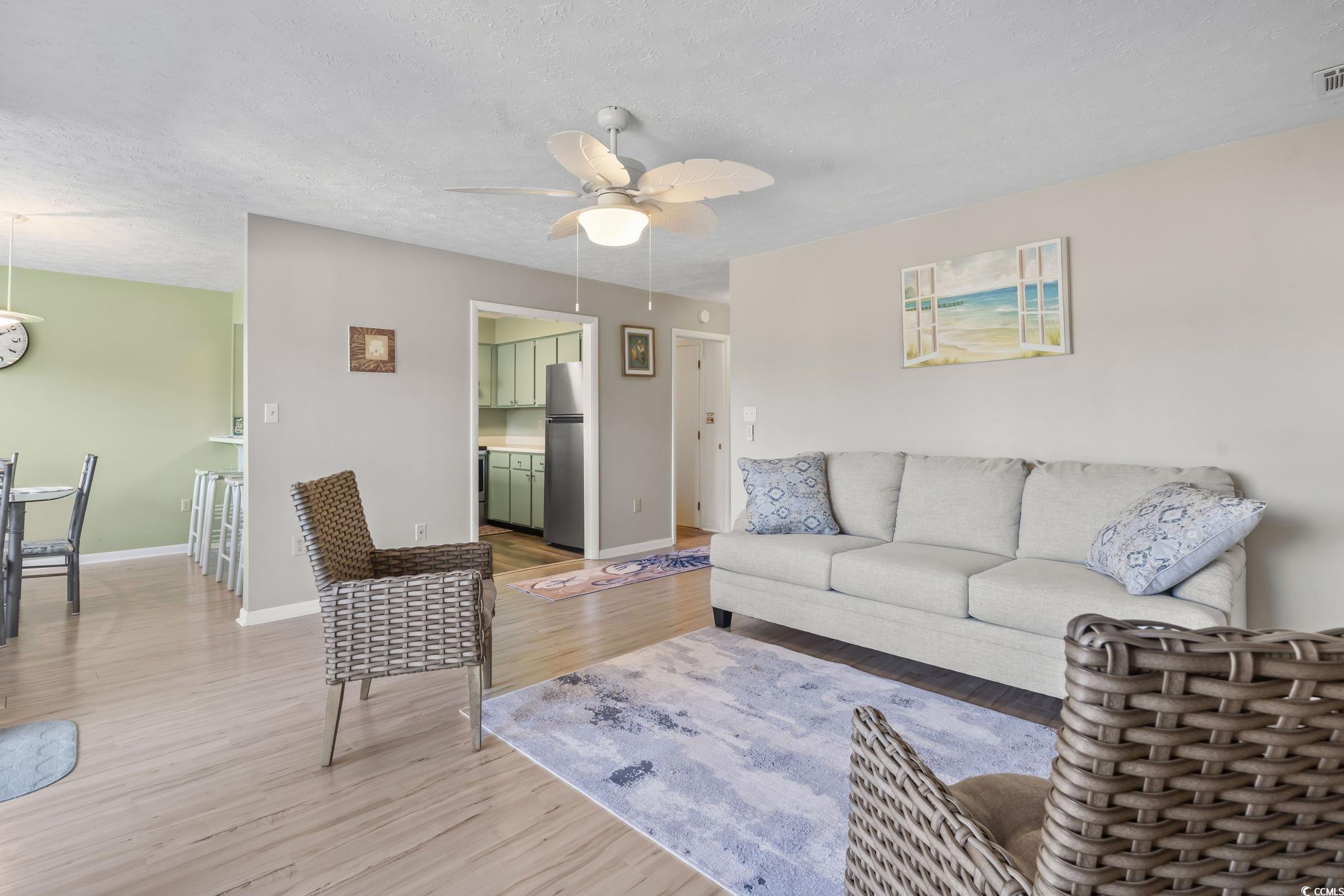 310 5th Avenue North, Unit 206 Surfside Beach, SC 29575 - Photo 4 of 40 Living room with a textured ceiling, light wood-type flooring, and ceiling fan