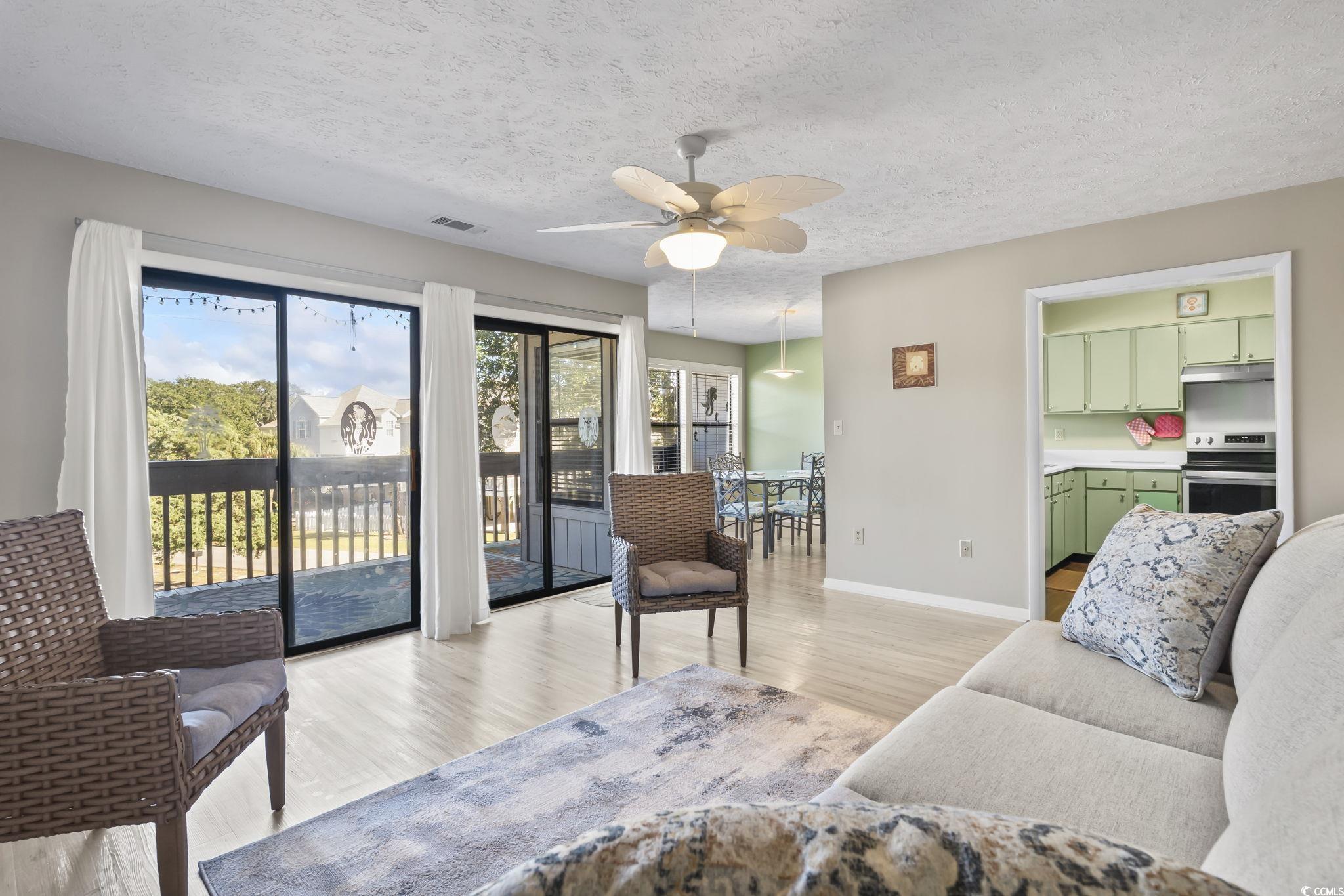 310 5th Avenue North, Unit 206 Surfside Beach, SC 29575 - Photo 5 of 40 Living area with a textured ceiling, light wood-type flooring, and ceiling fan