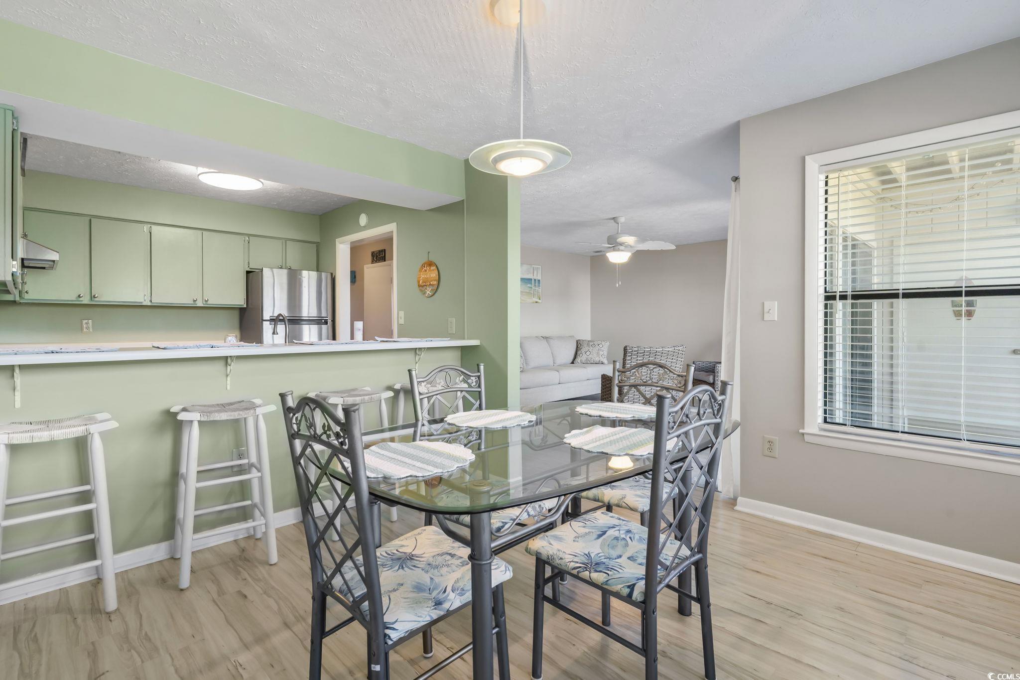 310 5th Avenue North, Unit 206 Surfside Beach, SC 29575 - Photo 6 of 40 Dining room featuring light wood-type flooring, a textured ceiling, and ceiling fan