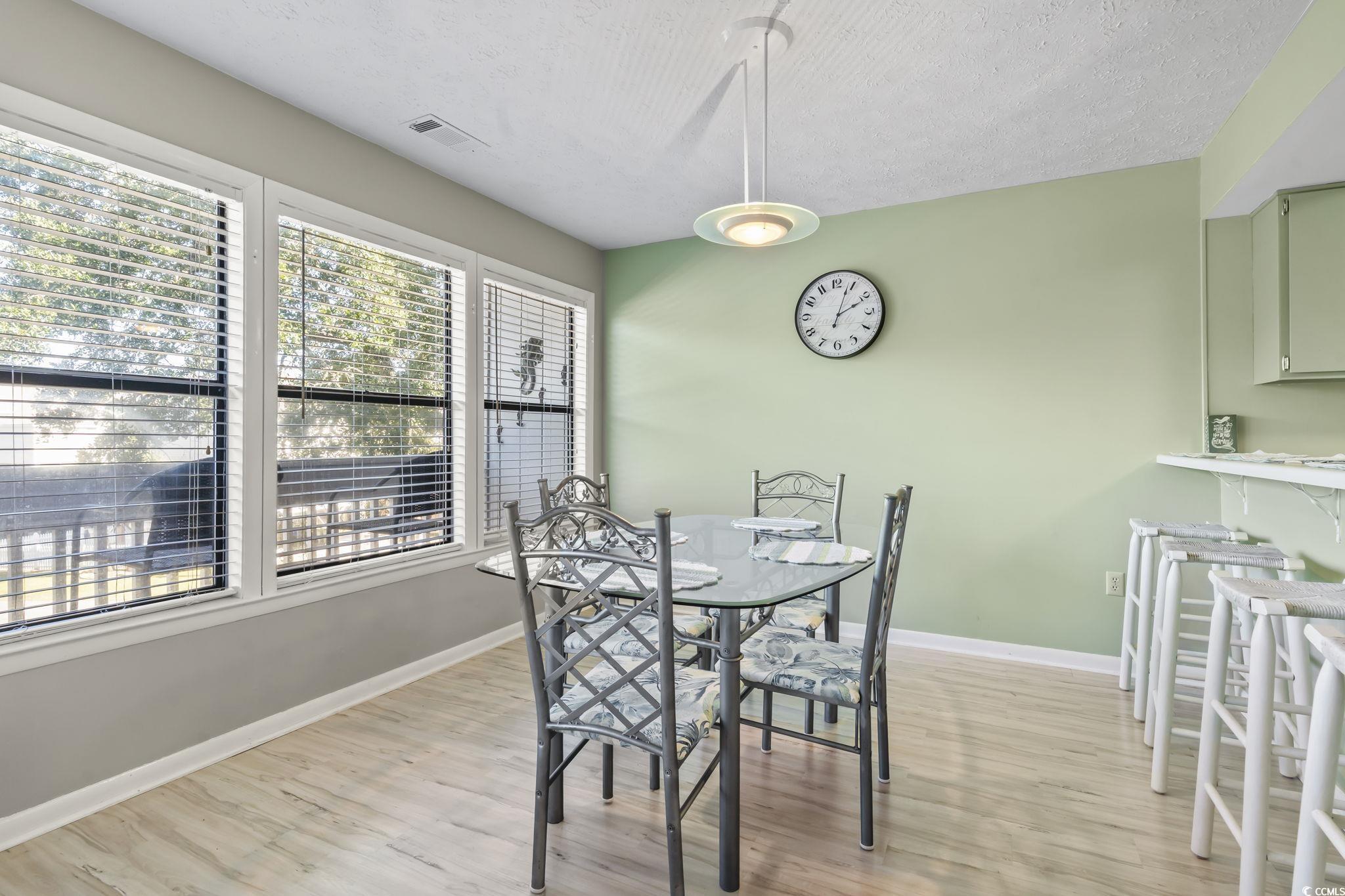 310 5th Avenue North, Unit 206 Surfside Beach, SC 29575 - Photo 9 of 40 Dining space featuring light wood-style floors and a textured ceiling