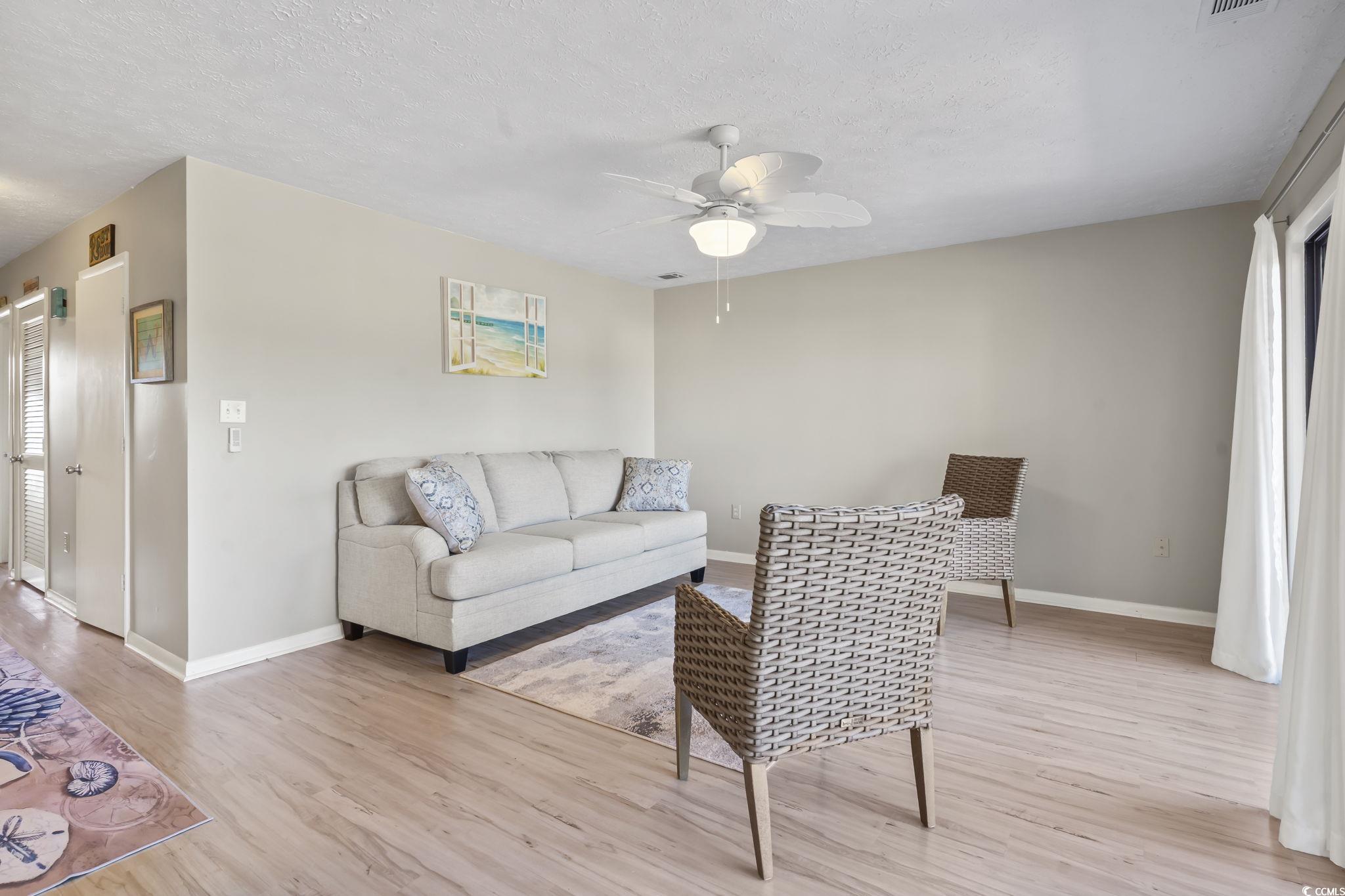 310 5th Avenue North, Unit 206 Surfside Beach, SC 29575 - Photo 10 of 40 Living room with light wood-style floors, a textured ceiling, and a ceiling fan