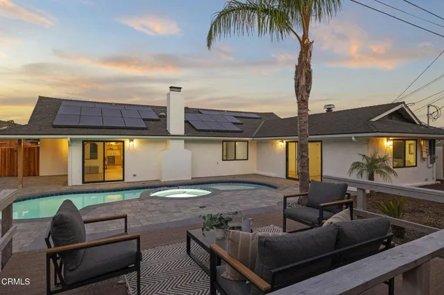 a view of a house with backyard and sitting area