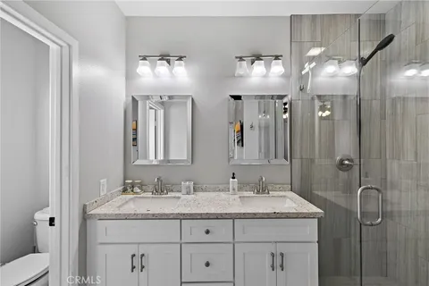 a bathroom with a granite countertop sink a shower and a mirror