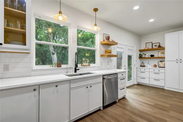 a kitchen with appliances cabinets and a large window