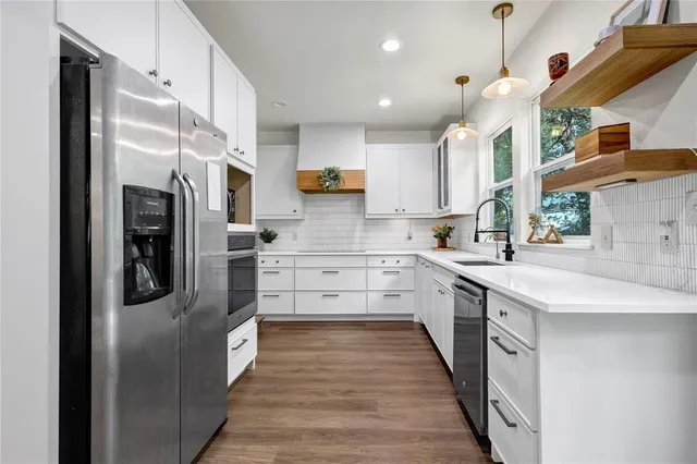 a kitchen with stainless steel appliances kitchen island granite countertop a refrigerator a sink and a stove
