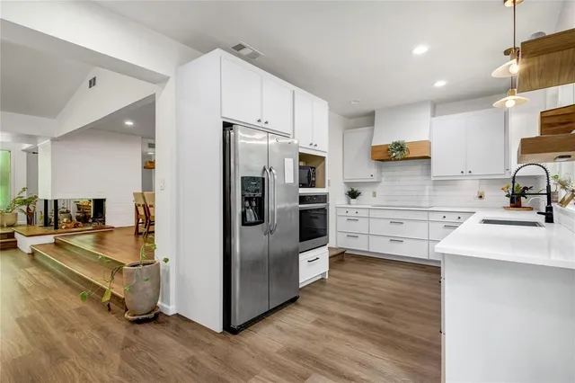 a kitchen with stainless steel appliances a refrigerator sink and stove