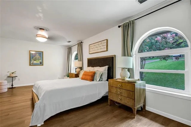 a bedroom with a bed wooden floor and window