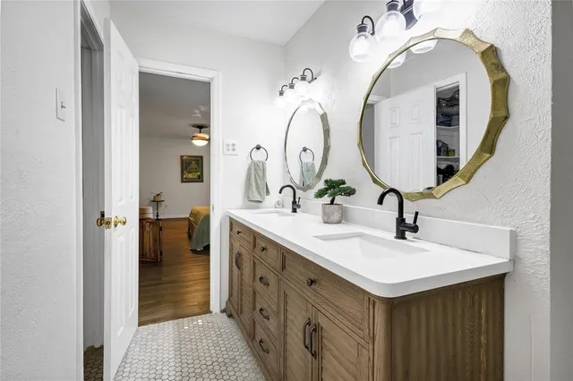 a en suite bathroom with a double vanity sink and a mirror