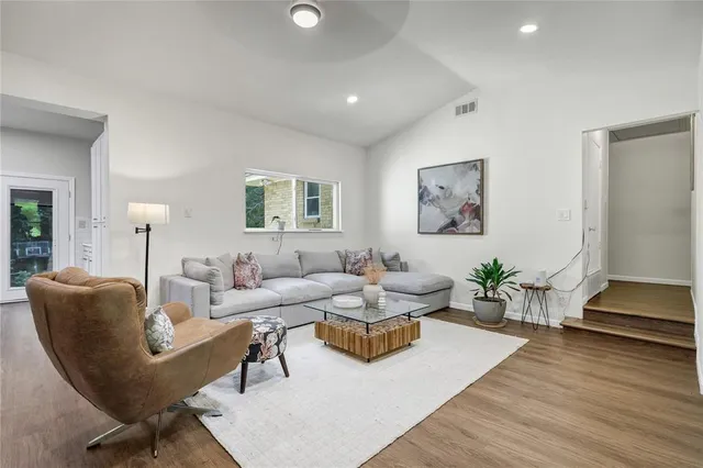 a living room with furniture and wooden floor