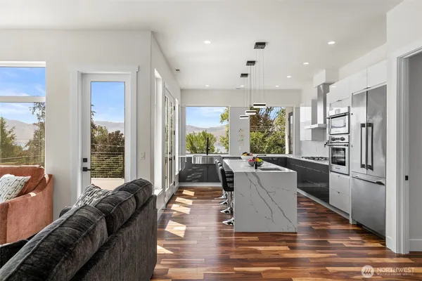a living room with furniture wooden floor and a large window