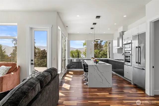 a living room with furniture wooden floor and a large window