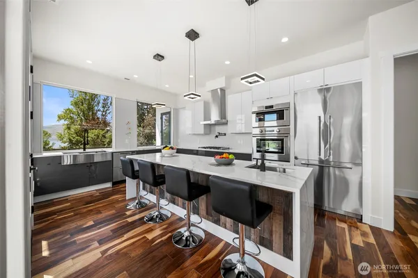 a kitchen with stainless steel appliances a stove a refrigerator and a fireplace
