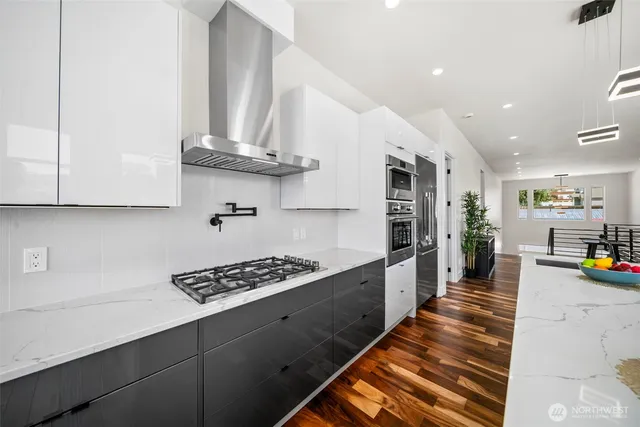 a kitchen with stainless steel appliances granite countertop a lot of cabinets a stove and a sink