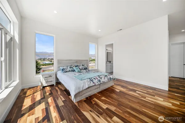 a bedroom with a bed and wooden floor