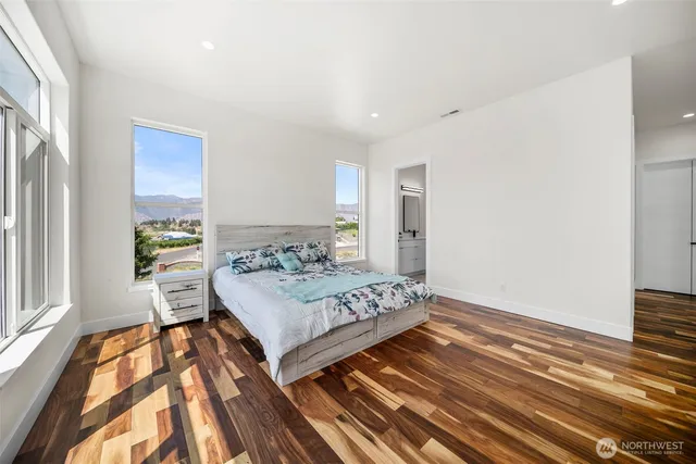 a bedroom with a bed and wooden floor