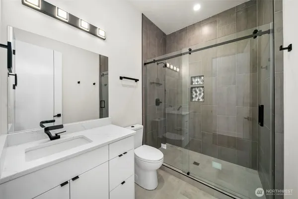 a bathroom with a shower sink a toilet and shower