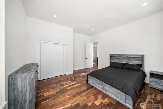 a bedroom with a bed and wooden floor