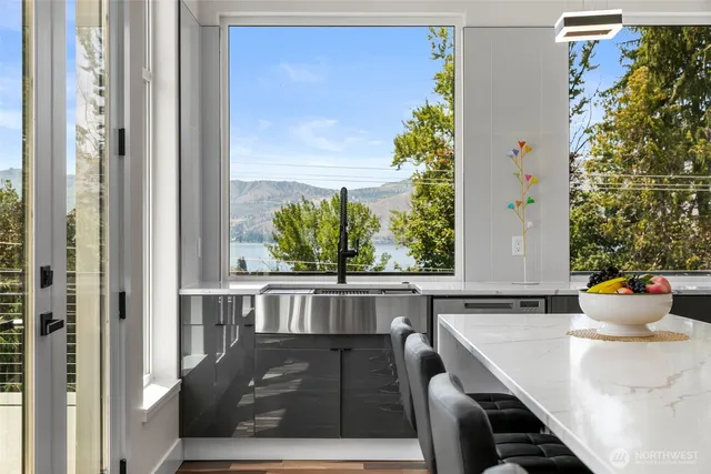 a living room with a large window and potted plants
