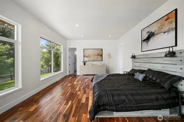 a bedroom with a bed and wooden floor