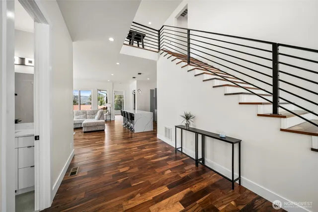 a view of a hallway with wooden floor and staircase