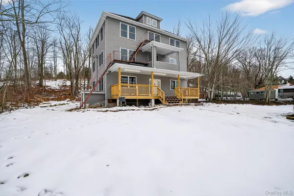 a front view of a house with a yard covered with snow