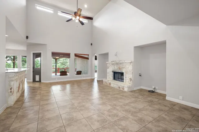 an empty room with fireplace and windows